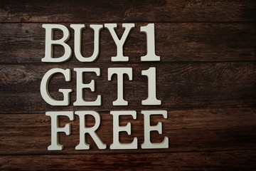 Buy 1 Get 1 Free with space copy on wooden background