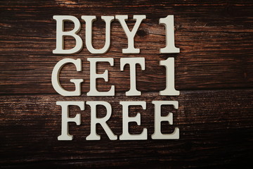 Buy 1 Get 1 Free with space copy on wooden background