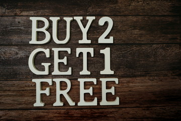 Buy 2 Get 1 Free with space copy on wooden background