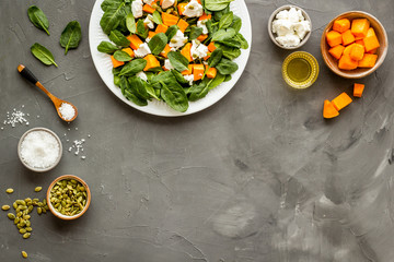 Cooking salad with pumpkin and basil. Ingredients on grey background top-down copy space