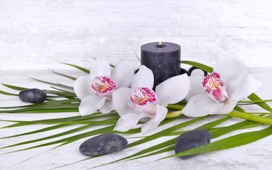 arrangement  with beautiful white orchids, pebbles and candle