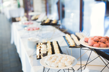 Delicious sweets on wedding candy buffet with desserts, cupcakes