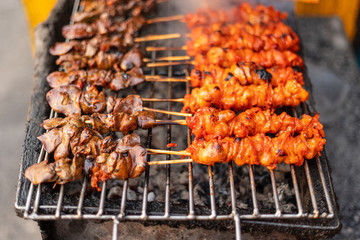 Chicken satay skewer on bbq coal grill.