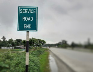 Service road end white text on green board at the highway