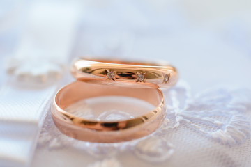 Obraz na płótnie Canvas two gold wedding rings with diamonds for engagement