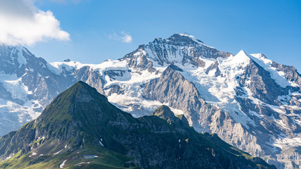 Fototapeta na wymiar Switzerland, Panoramic view on Eiger, Monch and Jungfraujoch and green Alps around Mannlichen