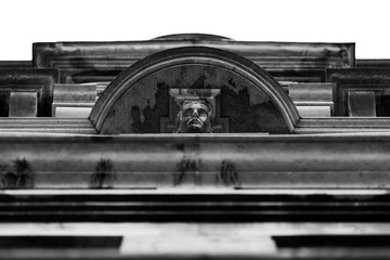 detail of face on roofline of old building