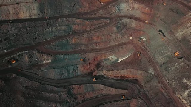 Panorama aerial view shot open pit mine coal mining, dumpers, quarrying extractive industry stripping work. Big Yellow Mining Trucks. View from drone at opencast mining with lots of machinery trucks