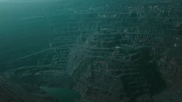 Panorama aerial view shot open pit mine coal mining, dumpers, quarrying extractive industry stripping work. Big Yellow Mining Trucks. View from drone at opencast mining with lots of machinery trucks