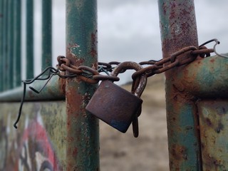 Rusty Padlock on the gate in the meadow fence. Slovakia