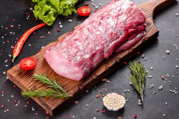 Fresh pieces pork ready to cook on a dark background in the kitchen