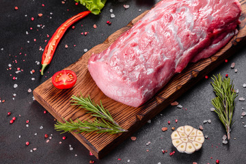 Fresh pieces pork ready to cook on a dark background in the kitchen