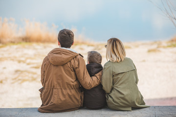 young beautiful family sitting at beach with view lake