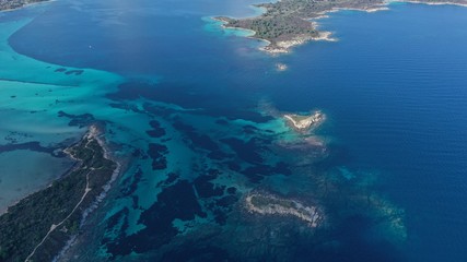 Aerial footage of small islets in turquoise water of Aegean sea, Halkidiki, Sithonia peninsula, Vourvourou beach, Kavourotripes beach, Greece. Beautiful landscape. Small islands. Stones underwater.