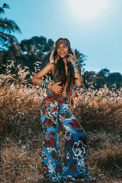 beautiful young hippie style woman close up portrait at sunset on a field