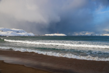 Coast of the Arctic ocean. Surfers swim in the icy waters of the ocean, Teriberka, Russia