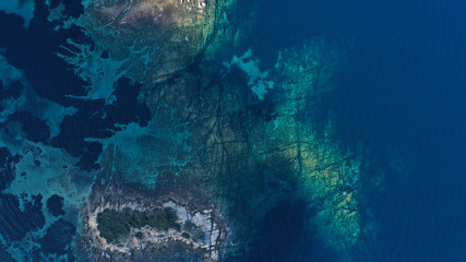 Aerial view of Aegean sea, turquoise water surface, Vourvourou beach, Kavourotripes beach, Sithonia peninsula, Halkidiki, Greece. Rocks, stones underwater.