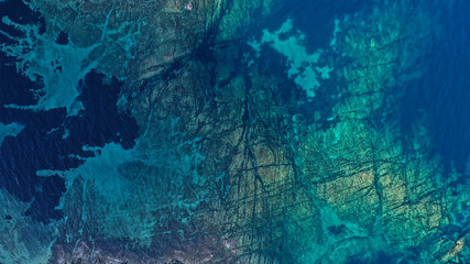 Fototapeta na wymiar Aerial view of Aegean sea, turquoise water surface, Vourvourou beach, Kavourotripes beach, Sithonia peninsula, Halkidiki, Greece. Rocks, stones underwater.