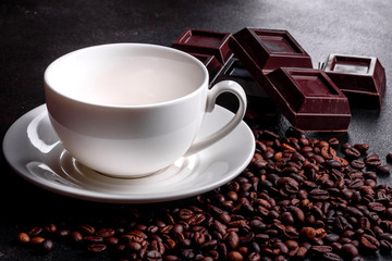 Preparation of aromatic morning coffee. Empty white coffee cup on a dark table