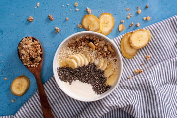 Healthy pineapple, mango smoothie bowl with coconut, bananas, blueberries and granola. Top view scene on a bright background.