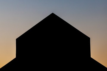 abstract silhouette of triangular building at sunset