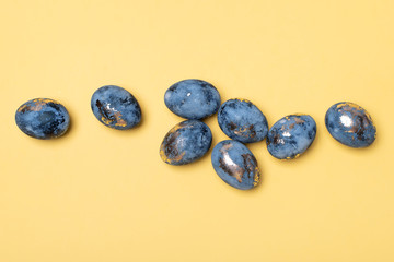 Flat Lay of Golden Easter Eggs in row placed on yellow background. Easter background or easter concept.