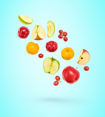 Flying Fruits healthy food summer color background. Apple, plum, grape. Colorful levitation, falling fly fruit creative vitamin concept. Fresh tropical fruit on blue