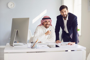 Arab and european businessman working confident in a white office.