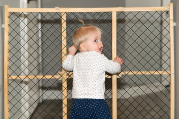 Cute Baby Playing Behind Safety Gate