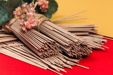 Naklejka premium Dried Organic Buckwheat Soba Noodles Ready to Cook on red background - Image
