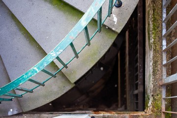 looking down spiral staircase with moss covered wall