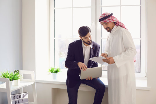Arab and european businessman working confident in a white office.
