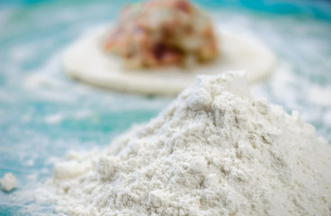 Close up of woman making food from flour and meat in the home kitchen.