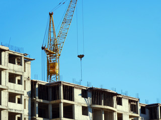 Crane. Self-erection crane over construction site. Crane near bulding. Industrial background.