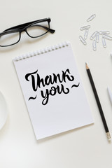 Workspace with pen, paper, coffee cup and office supplies.