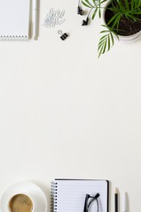 Workspace with pen, paper, coffee cup and office supplies.