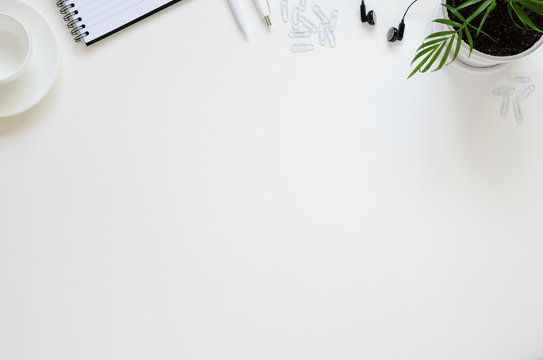 Workspace with pen, paper, coffee cup and office supplies.
