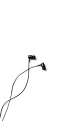 Obraz premium Black earphones lying on the white background. Modern music concept. Audio technology.