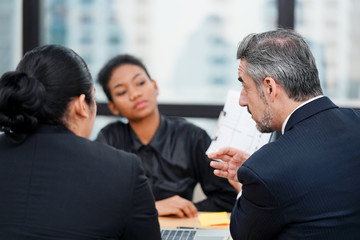 Businesspeople discussing together about the project ideas or results, negotiating, solving problems, brainstorming, planning in conference room during meeting at office.