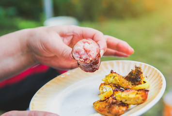 People eating grilled sausages, vegetables and meat. Sweet pepper and tomatoes. Good in village. Rustic style.