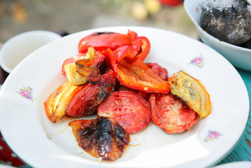 Grilled vegetables on the plate. Sweet pepper and tomatoes. Chicken frying.