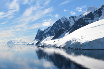 Landscape of snowy mountains and icy shores of the Lemaire Channel in the Antarctic Peninsula, Antarctica