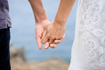 Couple holding their hands on the beach