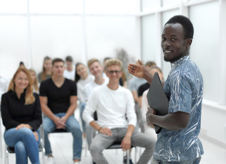 young man standing in front of the students of the business course