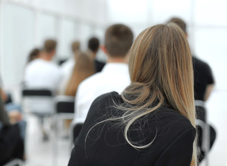 rear view. a group of diverse young people sitting in a conference room.