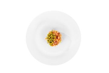 Russian salad with peas, red fish, chum salmon, eggs, cucumbers, carrots, potatoes on plate, view from above, white isolated background