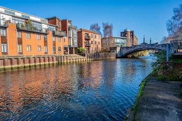 A view from the bankside of the River Wensum in the city of Norwich on a bright and sunny day