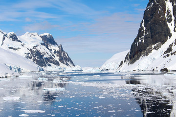 Fototapeta na wymiar Landscape of snowy mountains and icy shores of the Lemaire Channel in the Antarctic Peninsula, Antarctica