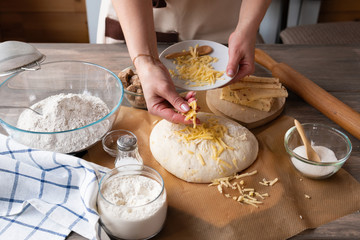 Ingredients and dough for bread on a wooden table, for baking baguettes