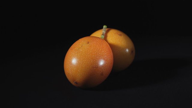 Video of rotating exotic granadilla on black background